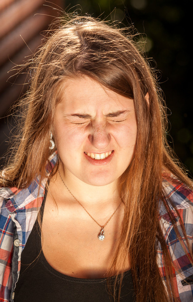 Portret van brunette vrouw huiverend van fel licht - Foto, afbeelding