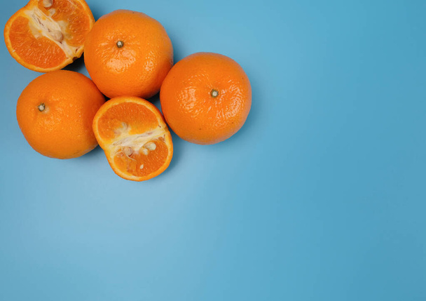 Čerstvé žluté pomeranče z polí na modrém pozadí - Fotografie, Obrázek