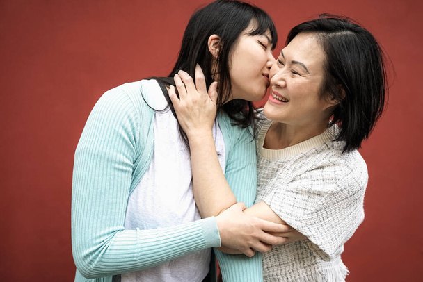 Happy Asian mother and daughter having tender moment together - Parents love concept - Photo, Image