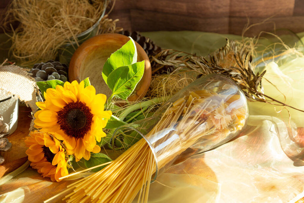 Girasoles en temporada de otoño, composición decorativa con pasta dentro de un frasco de vidrio - Foto, Imagen