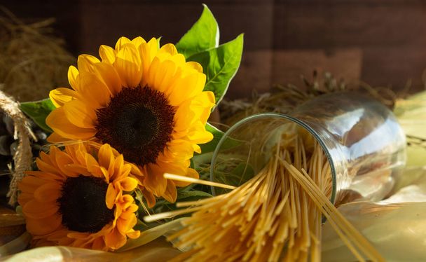 Słoneczniki jesienią, dekoracyjna kompozycja z makaronem w szklanym słoiku - Zdjęcie, obraz