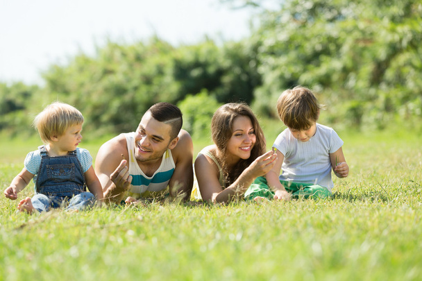 Eltern mit Kindern liegen im Gras - Foto, Bild