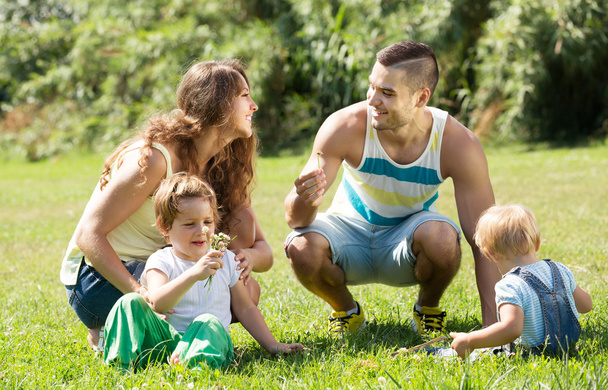 Famille de quatre personnes dans un parc ensoleillé - Photo, image