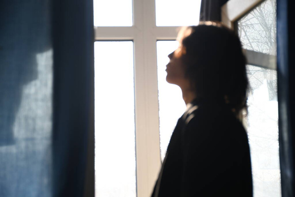 portrait of a beautiful young woman with a window - Zdjęcie, obraz