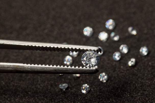 Diamonds are valuable, expensive and rare. For making jewelry. brilliant cut diamond held by tweezers. Beautiful diamond stone in tongs - Fotografie, Obrázek