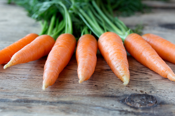 Some fresh carrots on old wooden desk - Фото, изображение