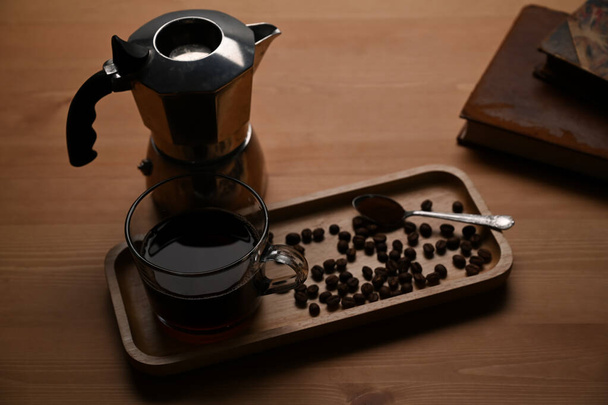 Moka cafetera y taza de café en la mesa de madera. - Foto, imagen
