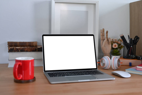 Posto di lavoro elegante con computer portatile, cuffie, libri e tazza di caffè. - Foto, immagini