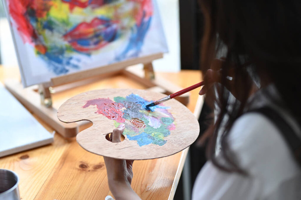 Umělec drží štětec míchání barvy olejomalba na paletě. - Fotografie, Obrázek
