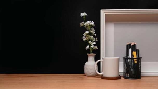Empty frame, coffee cup and pencil holder on wooden table. - Photo, Image