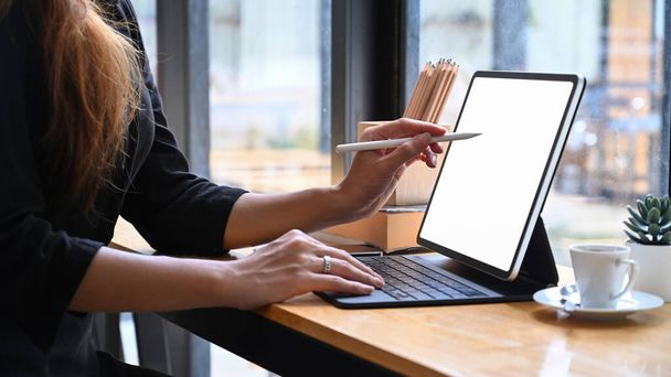 Zugeschnittene kreative Frau mit Stift zeigt auf Bildschirm des digitalen Tablets. - Foto, Bild