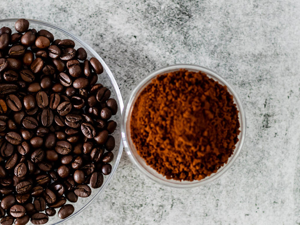 Kávová zrna podávaná v talíři s rozostřeným kávovým práškem - Fotografie, Obrázek