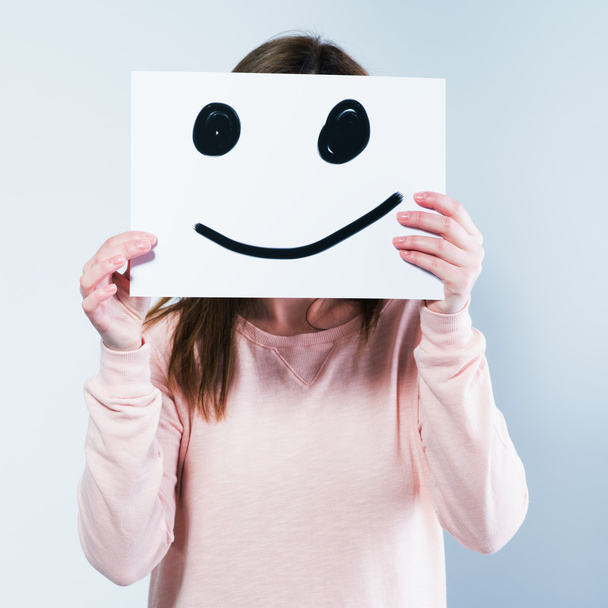 woman holding a cardboard with a smiley face - Photo, image