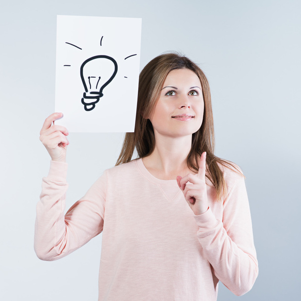 woman holding a paper with light bulbs - Zdjęcie, obraz