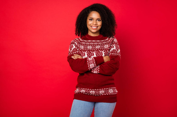 Portrait of attractive cheerful girl wearing knitted pullover folded arms isolated over bright red color background - 写真・画像