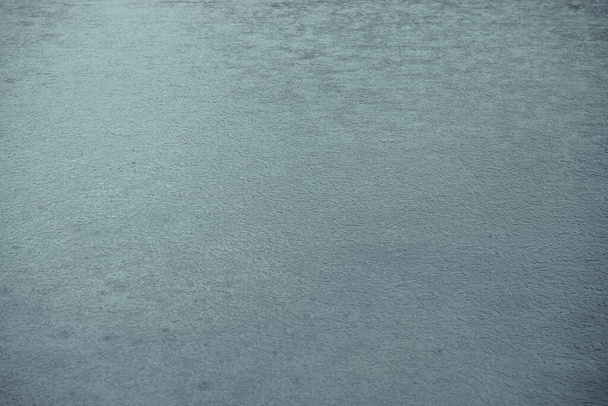Атмосферний характерний фон блакитної води в гірському озері. Тло природи з дощовими колами на поверхні води. Красивий мінімалістичний фрагмент блакитного гірського озера з дощовими колами
. - Фото, зображення