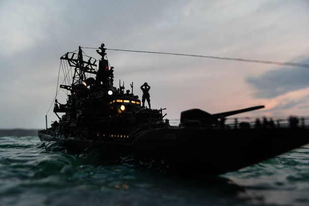 War concept. Night battle scene at sea. Dramatic toned clouds effect. Silhouette of the battle ship at sunset. Miniature creative table decoration. Selective focus - Fotoğraf, Görsel