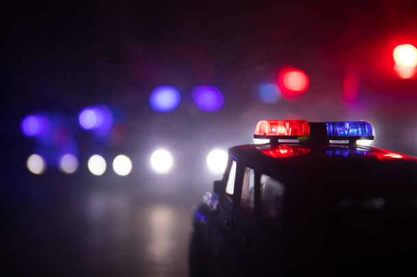 Полицейские машины ночью. Полицейская машина преследует машину ночью с туманным фоном. Полицейская машина скорой помощи 911 мчится на место преступления. Селективный фокус - Фото, изображение