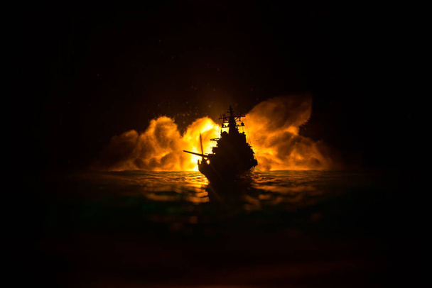 Válečný koncept. Noční bitevní scéna na moři. Dramatický efekt tónovaných mraků. Silueta bitevní lodi v noci. Miniaturní kreativní stolní dekorace. Selektivní zaměření - Fotografie, Obrázek
