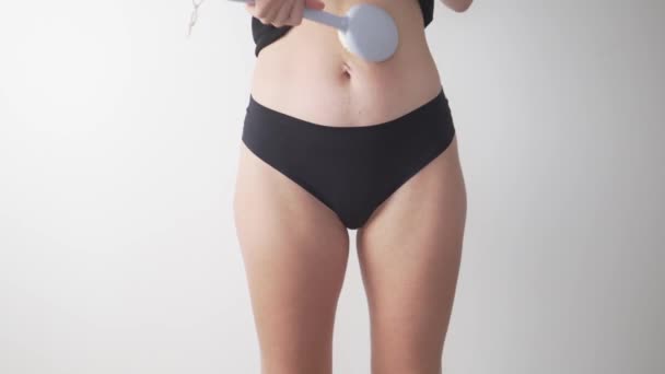 Nainen hieroo vatsaansa hierontaharjalla, lähikuva - Materiaali, video