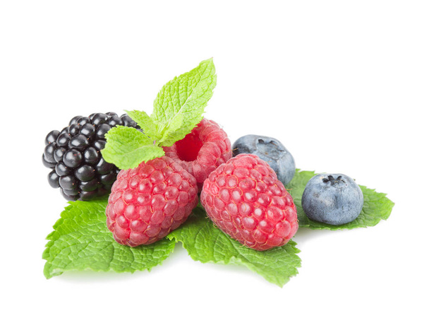 Mix of berries. Raspberries, blueberries and blackberries on a white background with leaves mint. Isolated. - Photo, Image