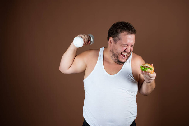 Étrend és egészséges életmód. Vicces kövér ember hamburgerrel.. - Fotó, kép