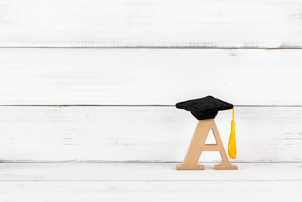 Education Hat with A Alphabet on white wood background. - Photo, Image