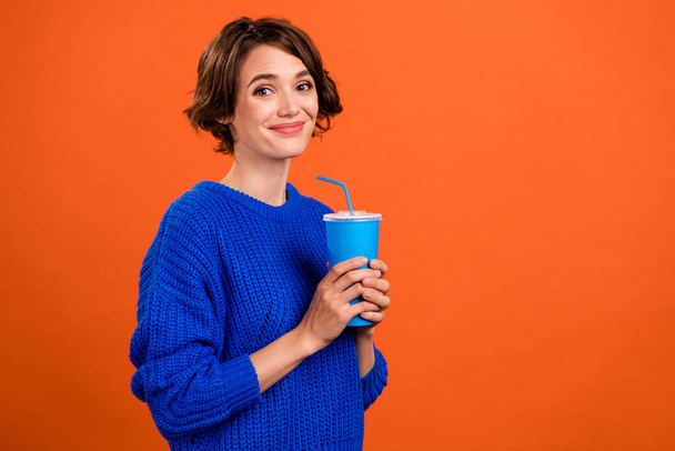 Foto retrato mujer sonriendo bebiendo gaseosa bebida aislado vívido naranja color fondo copyspace - Foto, Imagen