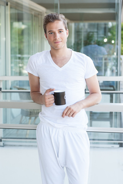 adulto joven sosteniendo una taza de café
 - Foto, imagen