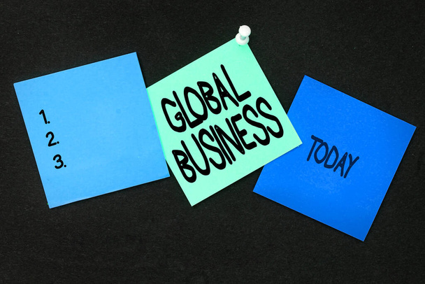 A Global Business felirata. Fogalmi fotó Kereskedelmi és üzleti rendszer egy cég csinál szerte a világon Több válogatott gyűjtemény irodai papír fotó kerül asztalra - Fotó, kép