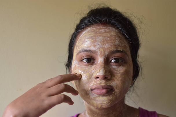 portré egy indiai hölgyről arcpakolással, félig szárított állapotban. Fogalom a nők szépségápolás otthon. - Fotó, kép