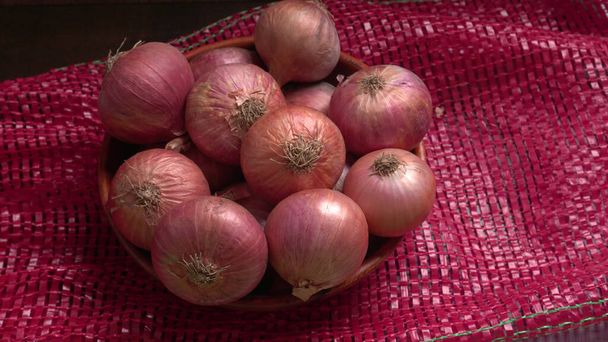 Fresh red onions in a wooden bowl - Photo, Image