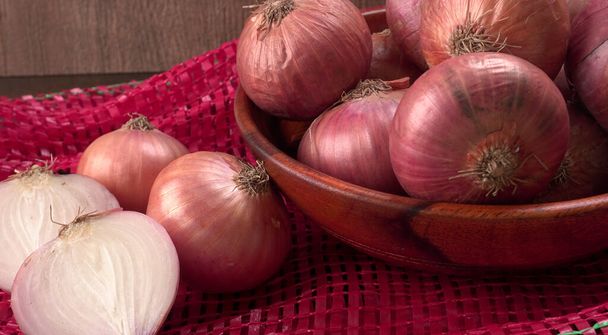 Cebollas rojas frescas en un tazón de madera
 - Foto, Imagen