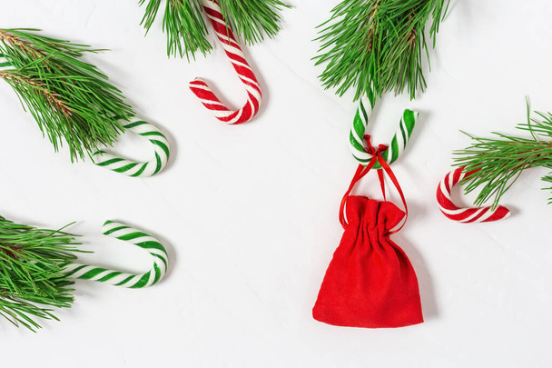 New Year gift. Christmas gift. Red surprise bag. Candy canes and branches of Christmas tree. Flat lay. Copy space. - Foto, Imagem