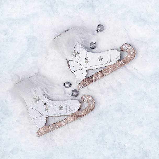 Retro style wooden skates on snowy background. Christmas toys, winter celebration concept. - Fotó, kép