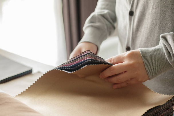 женщина-дизайнер с образцами цвета ткани, выбирающая текстиль для штор - Фото, изображение