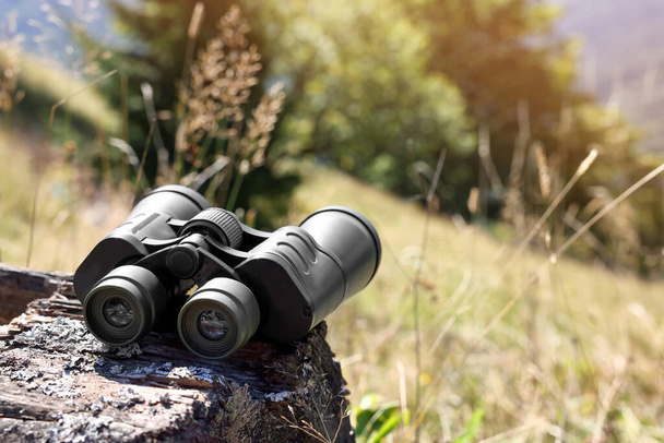 Modern binoculars on wooden surface outdoors, space for text - Foto, imagen