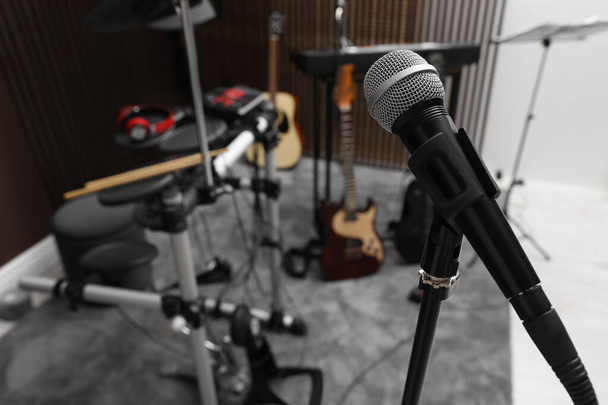 Modern microphone at recording studio, space for text. Music band practice - Фото, изображение