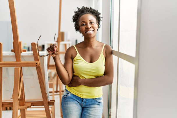 Young african american artist woman smiling happy standing at art studio. - Foto, Bild