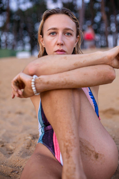 White european woman in swimsuit sitting on the sand - Foto, Bild