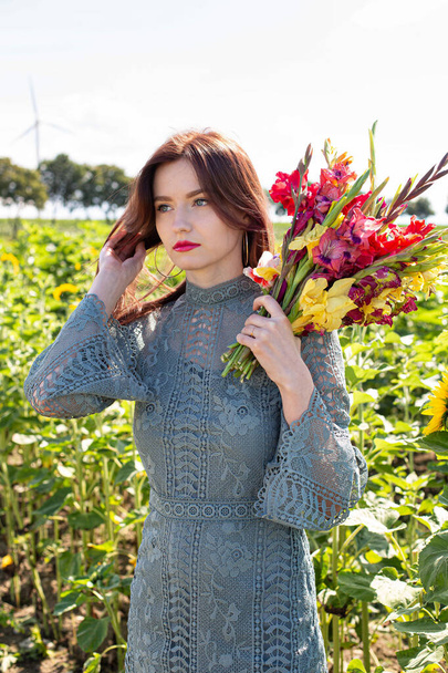 White young girl with dark hair standing with sunflowers behind - Foto, Imagem