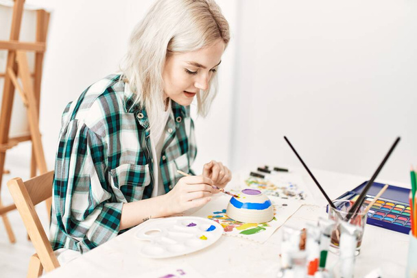 若い芸術家の学生の女の子リラックスした絵画陶器でアートスタジオ. - 写真・画像