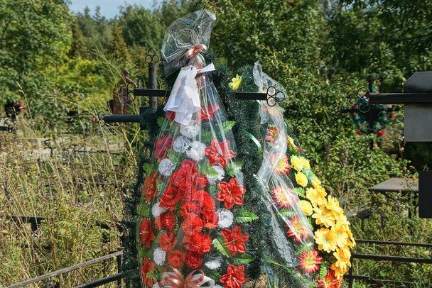 hautaaminen seppeleitä värillinen keinotekoinen muovi kukkia black metal rajat haudalla hautausmaalla - Valokuva, kuva