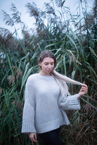 Young white european woman in white sweater in the tall grass - Foto, Bild