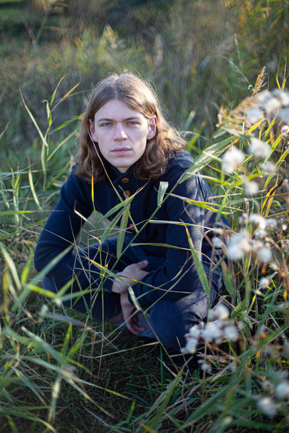 White young man with long hair on green grass - Foto, Imagen