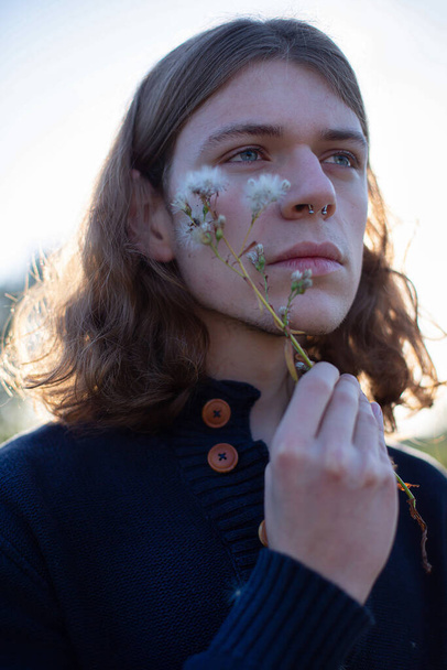 Young white man in dark sweater portrait with a branch near his face - Foto, Imagem