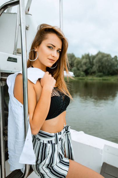 Beautiful girl resting on the yacht. Yachting. Luxury lifestyle. Beautiful woman in sunglasses on head and bikini relaxing on yacht. Luxurious life for woman enjoying travel, summer vacation - Fotografie, Obrázek