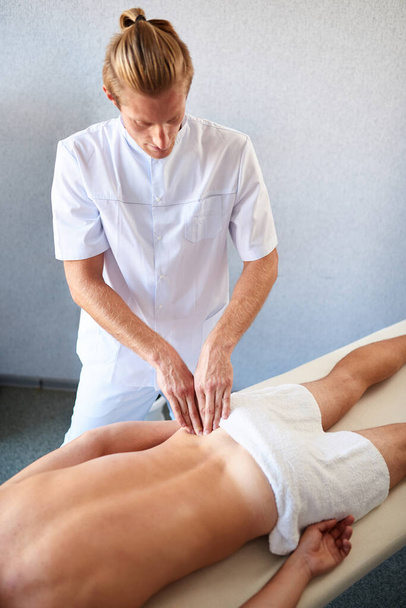Professional back massage for patient lying on massage table - Fotó, kép