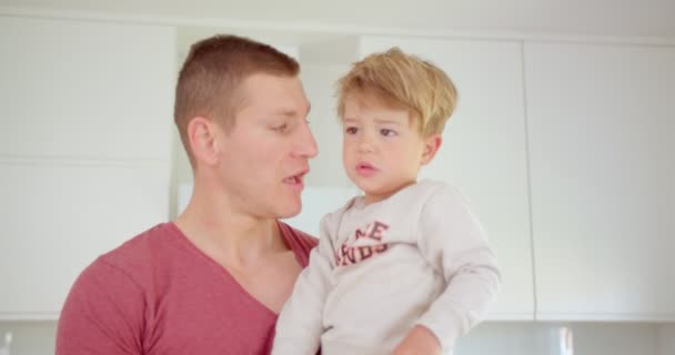 Pai bonito está falando com seu filho adorável enquanto ele espirra - Filmagem, Vídeo