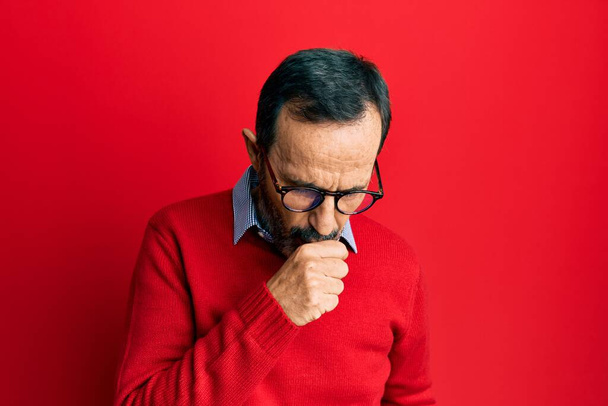 Middelbare leeftijd Spaanse man het dragen van casual kleding en glazen gevoel onwel en hoesten als symptoom voor verkoudheid of bronchitis. Gezondheidszorgconcept.  - Foto, afbeelding
